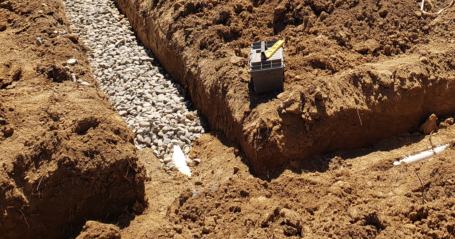 Drain field trench with piping laid on a hillside